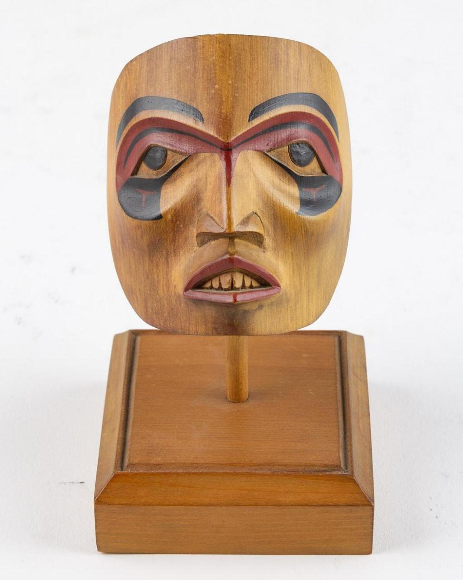 Chester Mclean - a small carved and polychromed mask with a stand