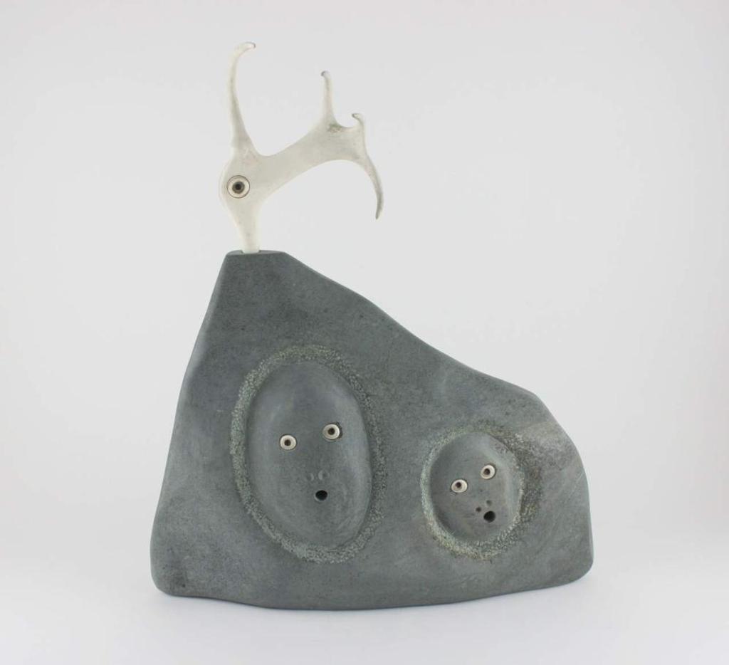 Matiusie Iyaituk (1950) - Ivujivik a green stone and antler carving of a Shaman with various faces.