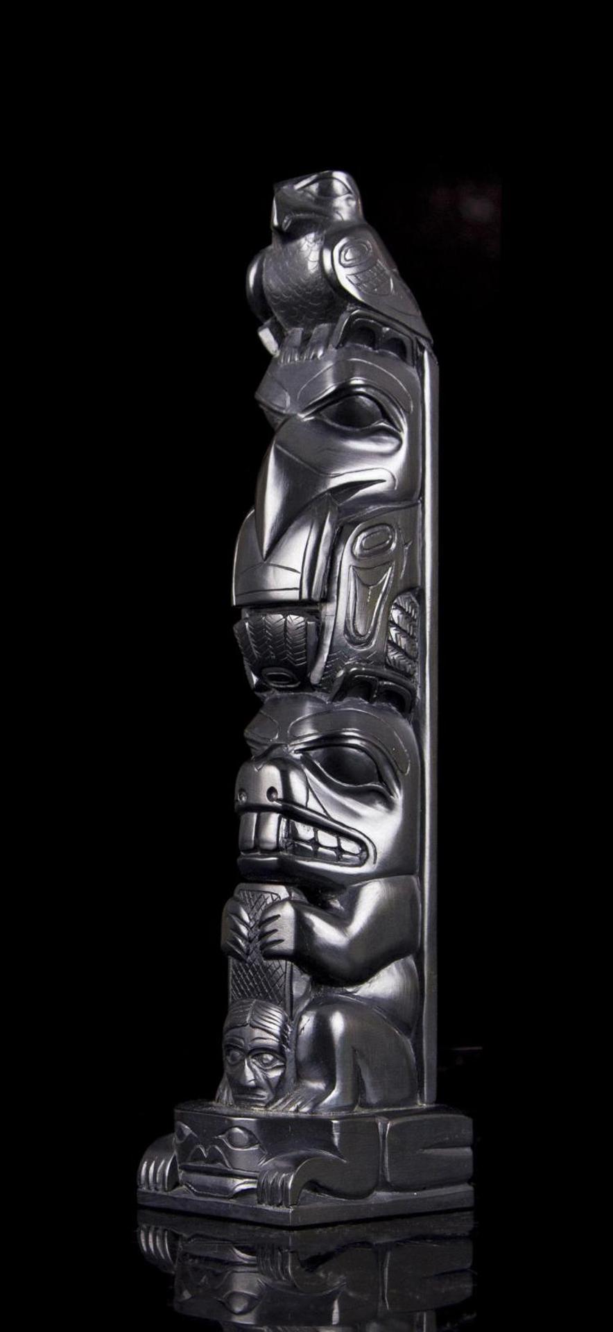 Tom Hans (1925) - a carved argillite three figure totem pole depicting Raven