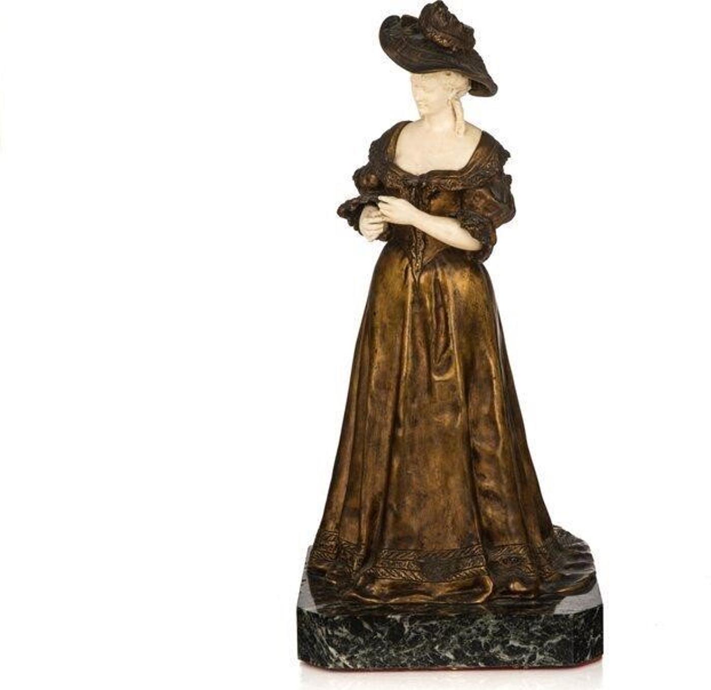 Armand Pierre Louis Quenard (1865-1925) - French bronze and natural material statue of a lady in late Victorian dress standing on a green variegated marble base. Signed 'Quenard' to the bottom hem of her skirts. French