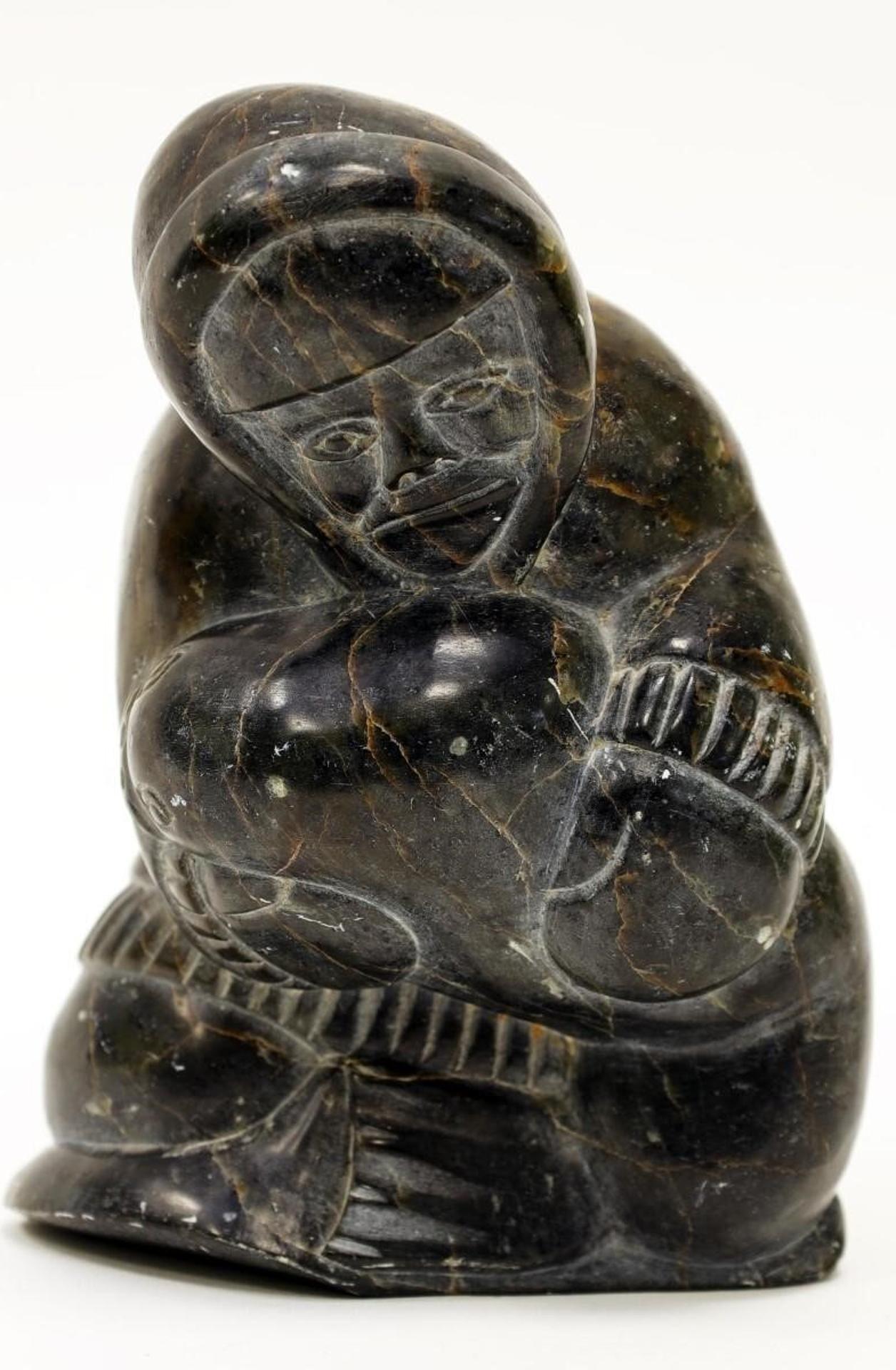 Mathewsie Amidlak (1934) - a dark grey-orange veined stone carving of a Hunter Hauling a Seal