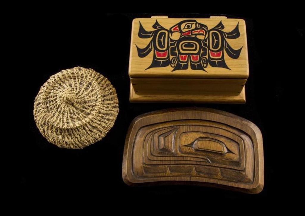 Larry Jacobson - a carved and stained cedar panel in the shape of an ovoid; together with a bentwood jewellery box decorated with an image of Raven