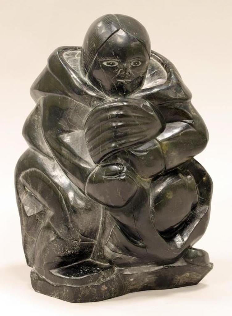 Annie Markosie (1935) - a dark grey stone carving of a Woman Carrying a Seal