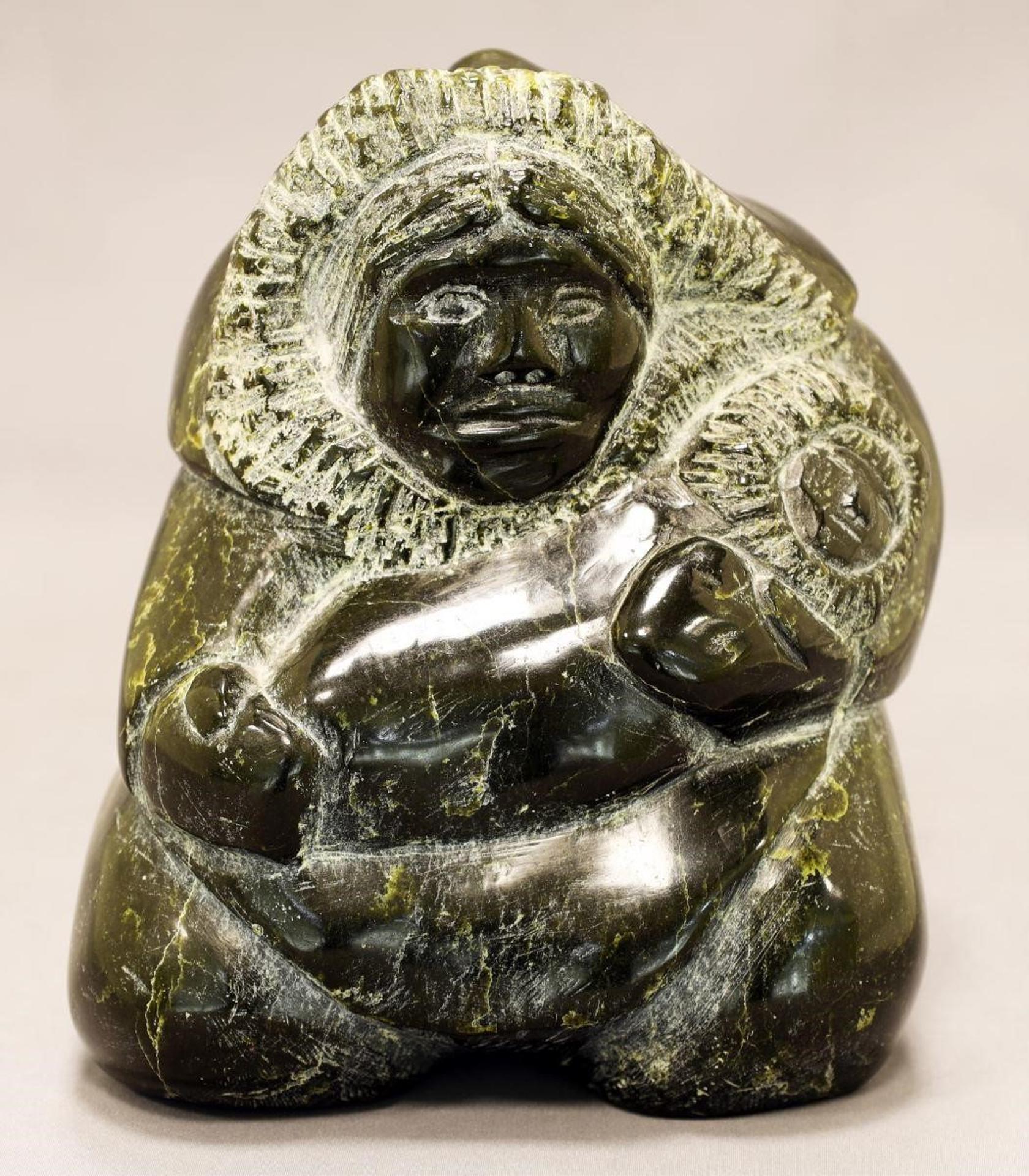 Enook Manomie (1941-2006) - a dark green serpentine carving of a Mother Holding Her Baby