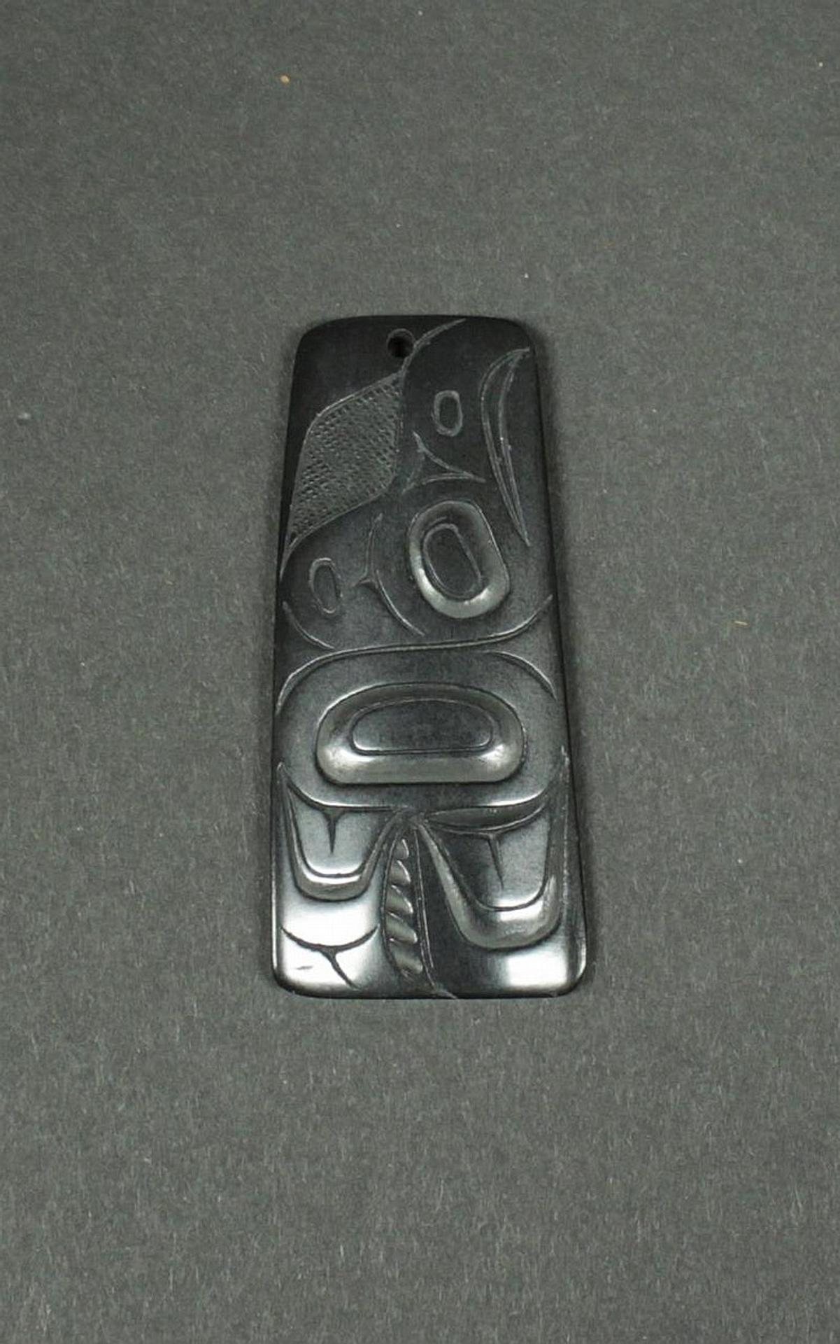Pat Dixon (1938-2015) - a carved argillite pendant depicting Raven