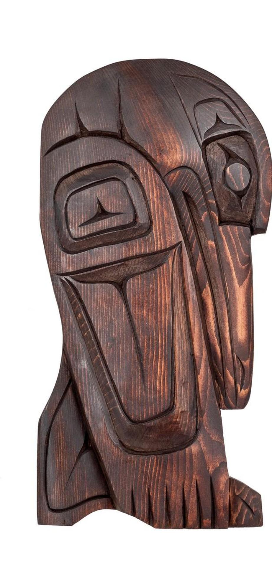 Roger Johnnie - a carved and stained cedar plaque depicting Raven