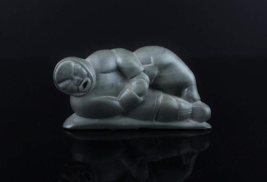 Saila - a grey stone carving of a hunter wrestling a seal