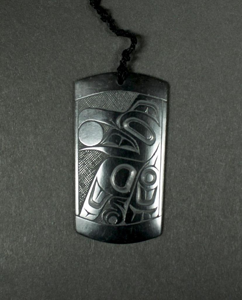 Pat Dixon (1938-2015) - a rectangular argillite pendant depicting Raven and the Sun