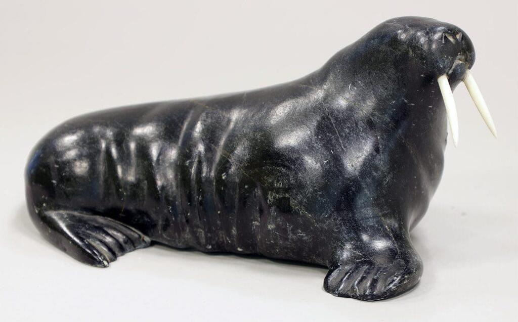 Aisapik Quma Igauja (1915-1979) - a dark grey-black stone carving of a Walrus with bone tusks