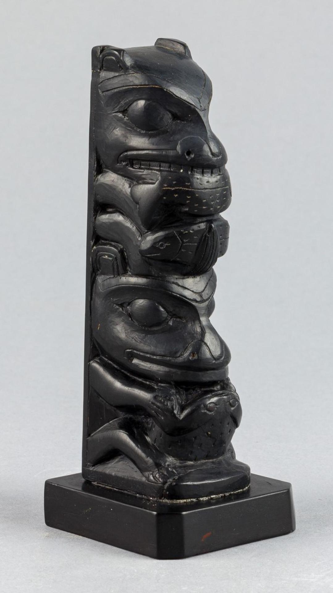 Mildred Pollard - a carved argillite pole depicting Wolf with Salmon