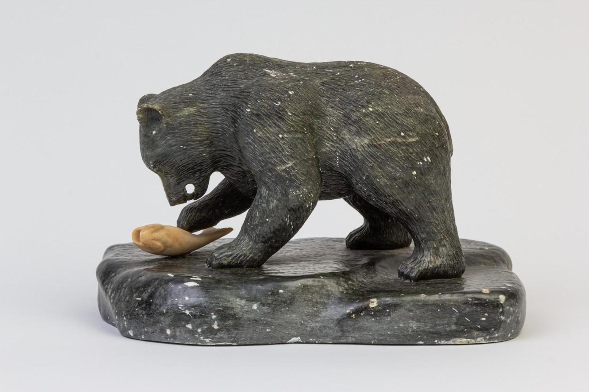 Dennis Labbe (1944) - a grey stone carving of a brown bear and salmon