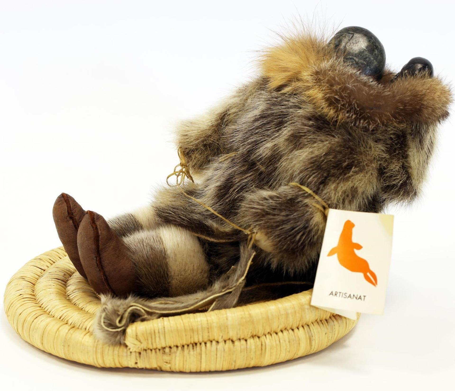Tyna Amidlak (1937) - a handmade multi-media doll (seal skin, animal fur, carved stone, cloth, hide, sinew and fabric, on a wicker base), depicting a Seated Mother with Baby in Amaut