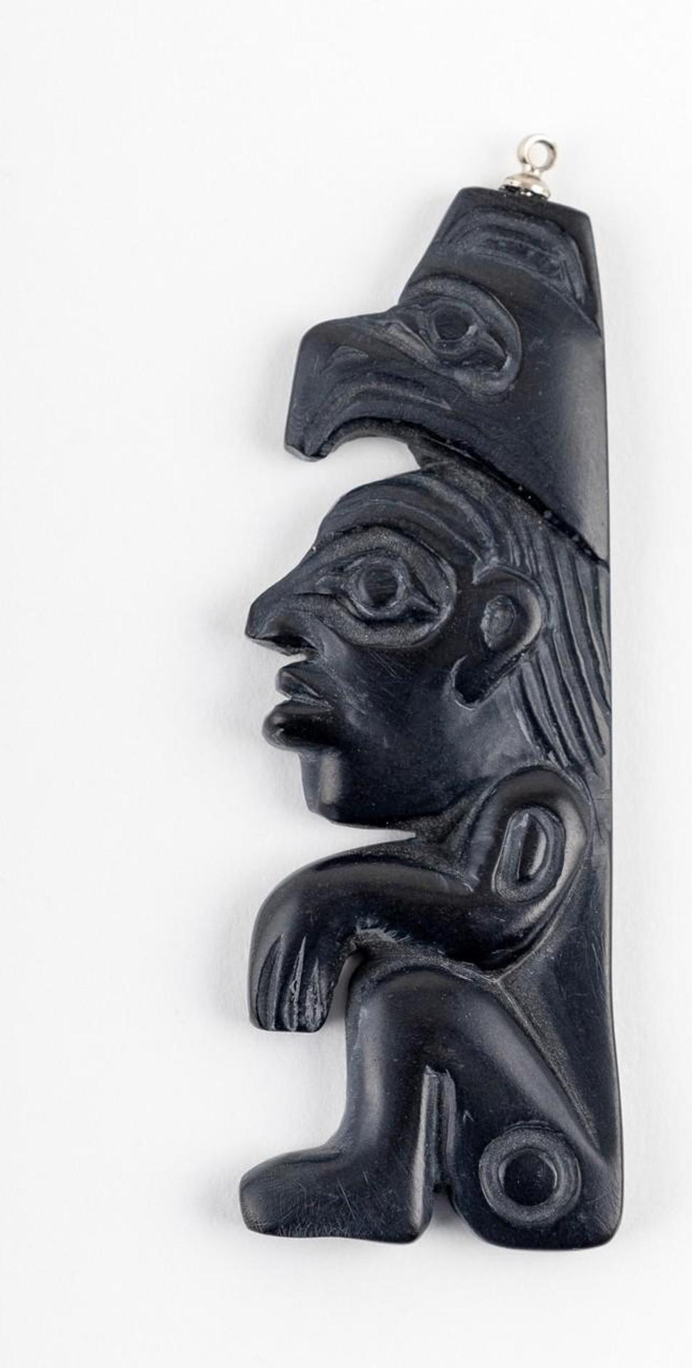 Greg White - a carved argillite pendant depicting a seated figure with a Raven atop his head