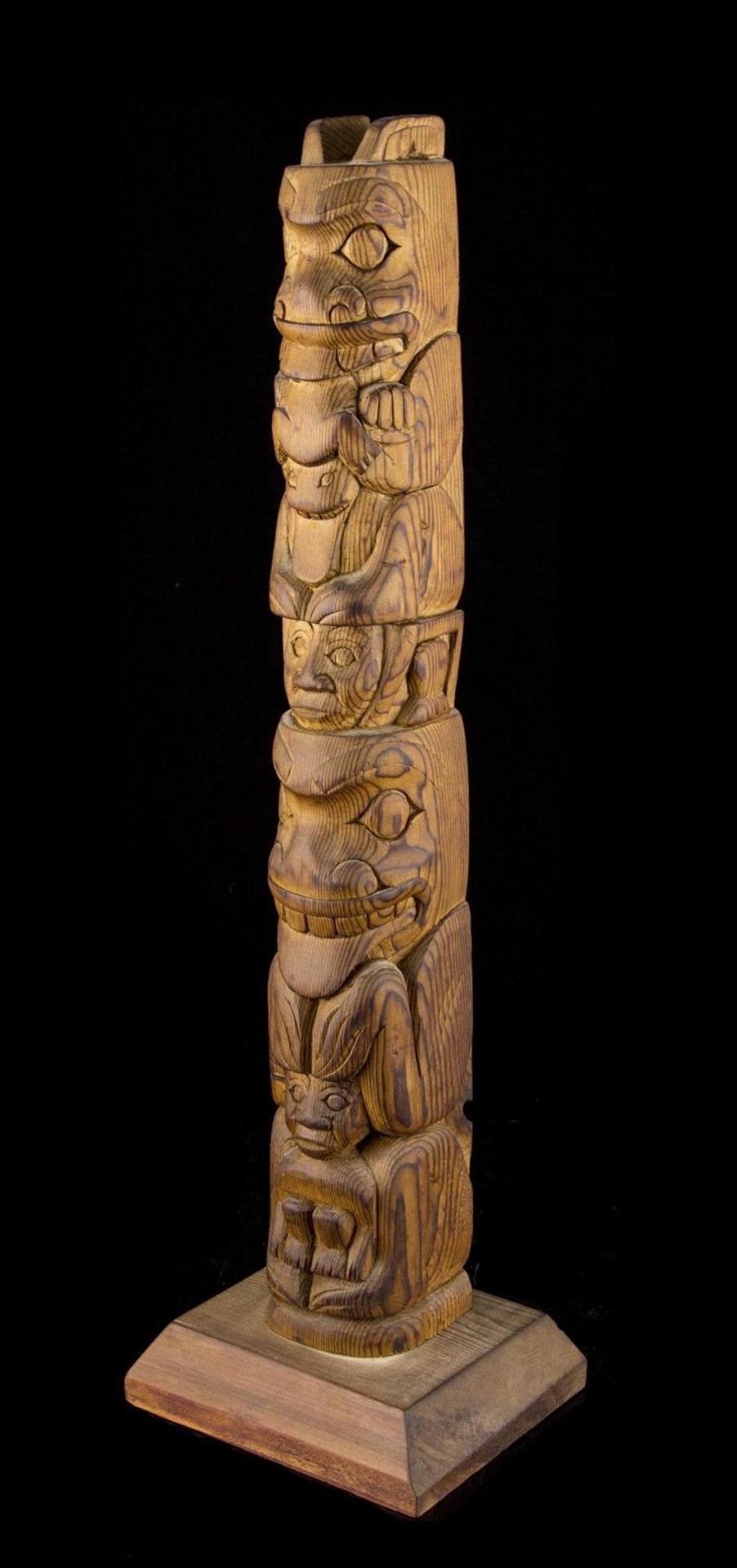 Ben Houstie (1960) - a carved red cedar totem pole depicting Bear eating Frog with Slave
