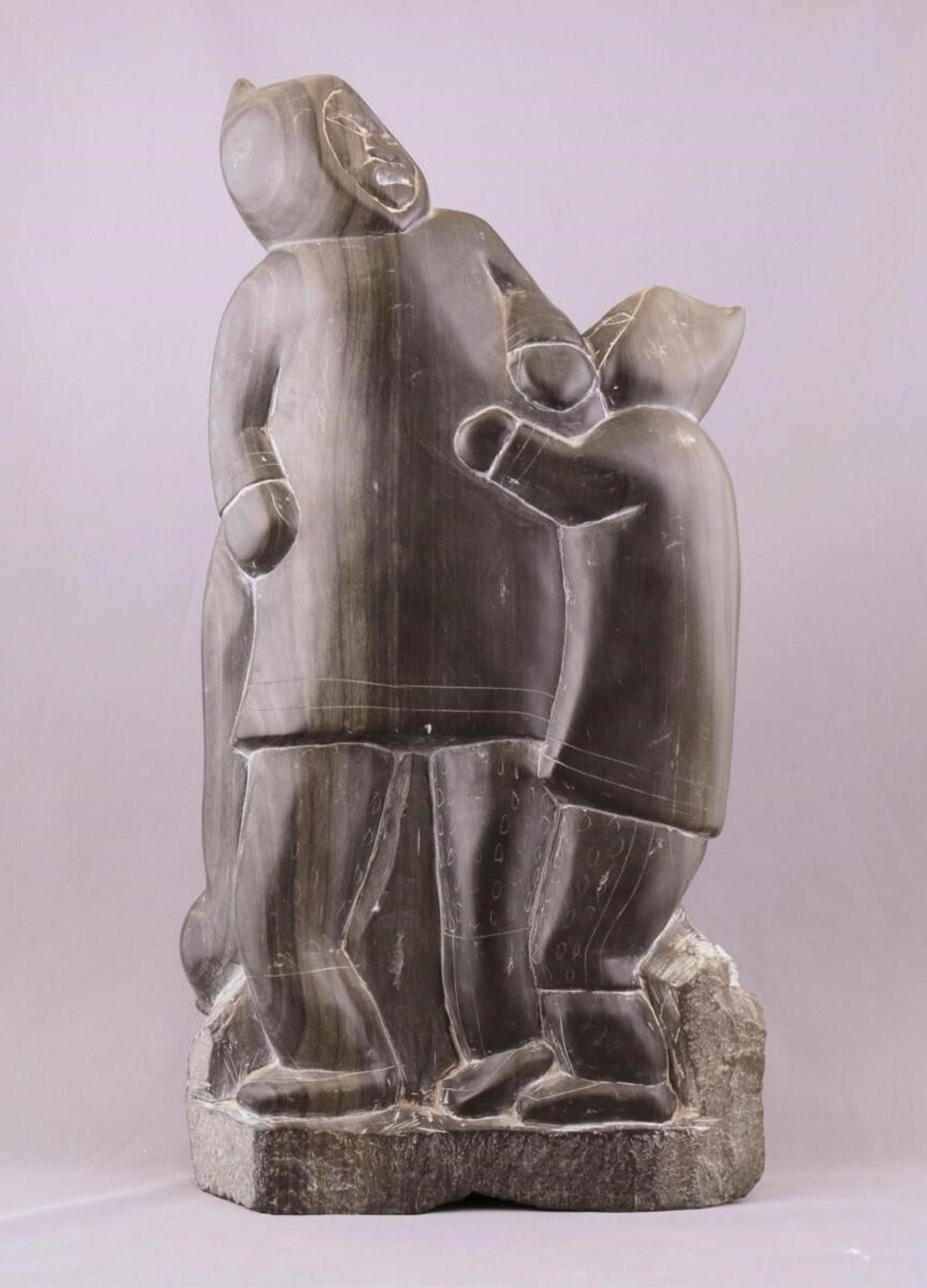 Pauloosie Paul Kavik (1948) - a grey-black stoned carving of a Hunter with Seal and Child