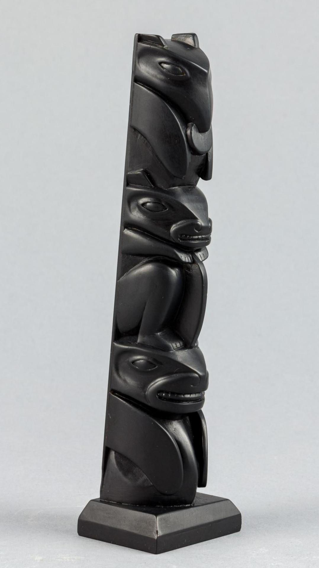 Bob Collison - a carved argillite pole depicting Raven holding the Sun