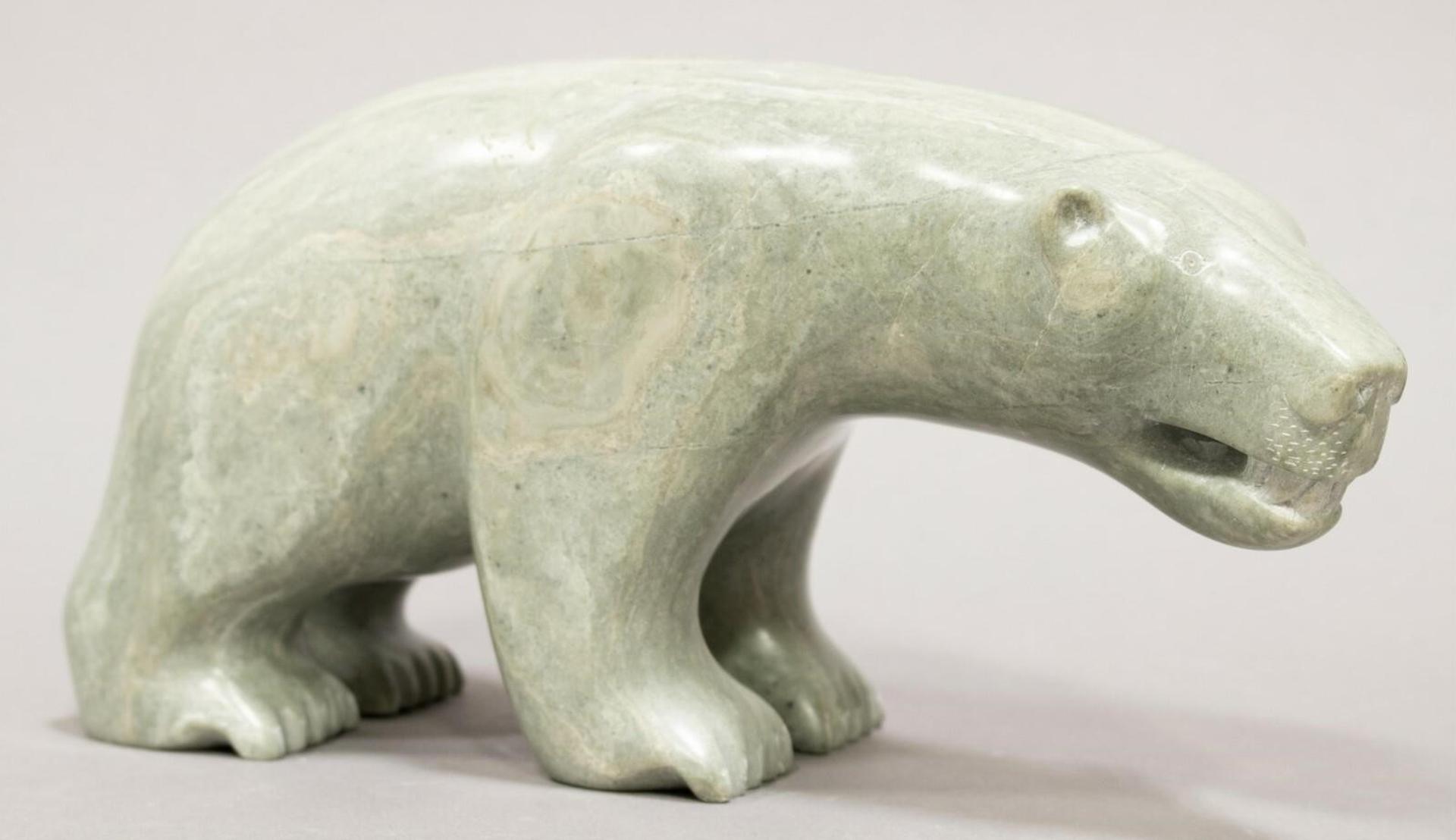 Paulassie Eqilaq (1934) - a light green-grey stone carving of a Polar Bear