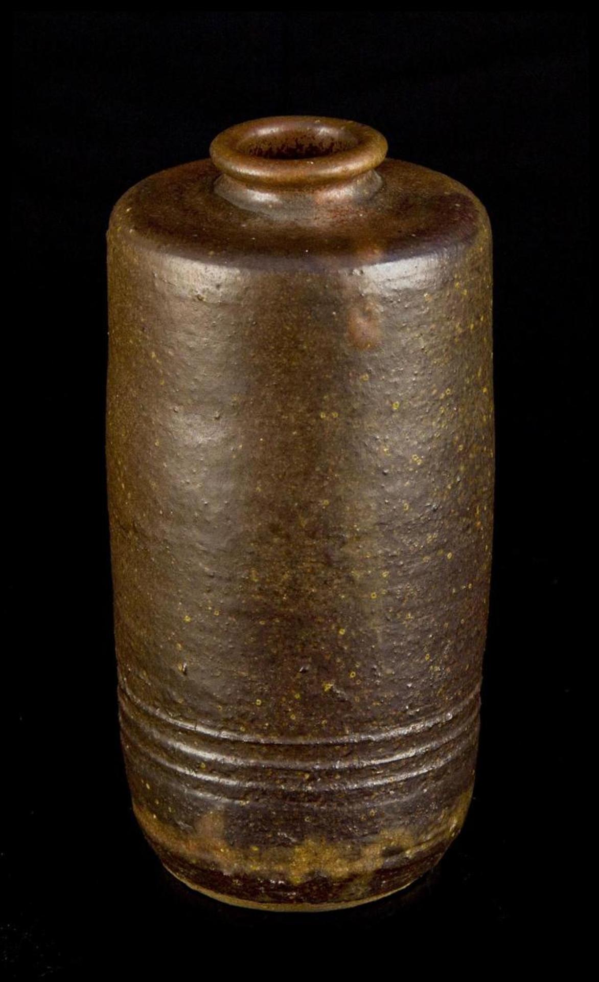 Wayne G. Ngan (1937-2020) - a brown cylindrical ceramic vase having a striped band near base