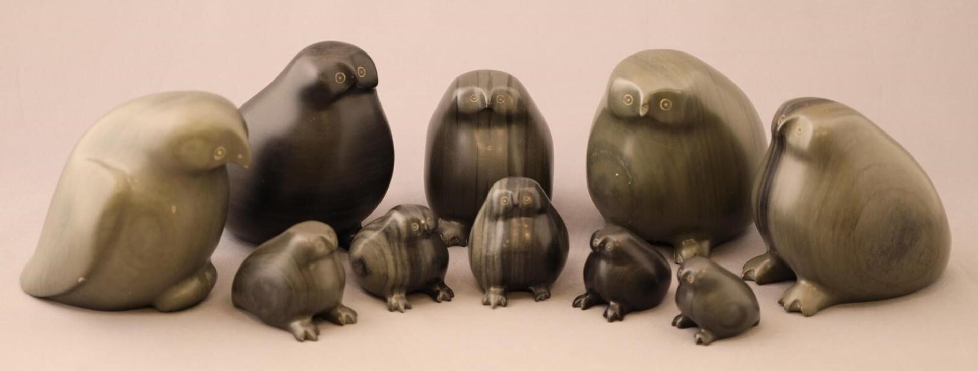 Mina Inuktaluk (1932) - an assembled grouping of grey and black carved stone Owls