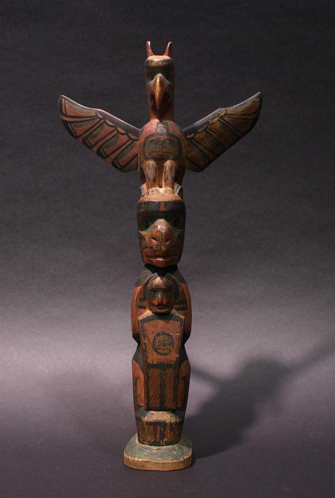 Charlie James (1865-1961) - a carved and polychromed model pole depicting Thunderbird atop Bear holding a copper
