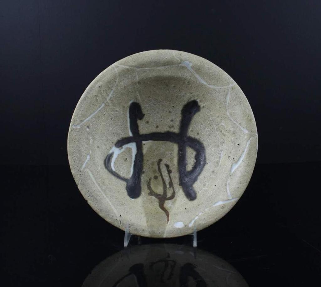 Wayne G. Ngan (1937-2020) - a ceramic bowl having a tan coloured ground with brown design to the interior