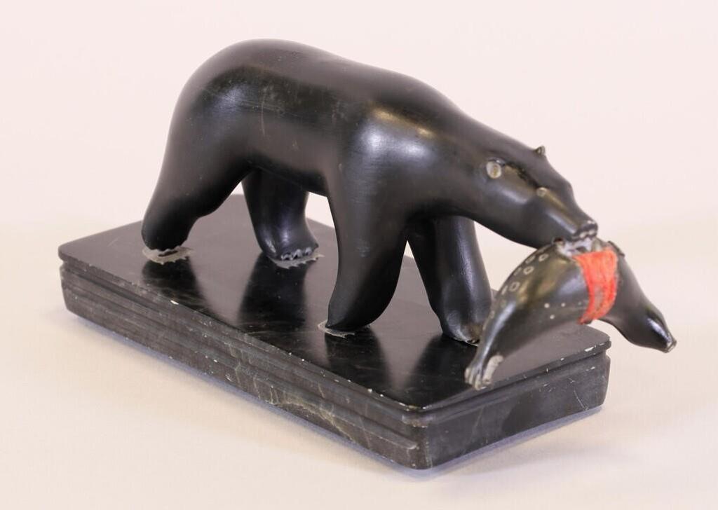 Alooloo Inutiq (1932-1985) - a black stone carving of a Bear Carrying a Seal