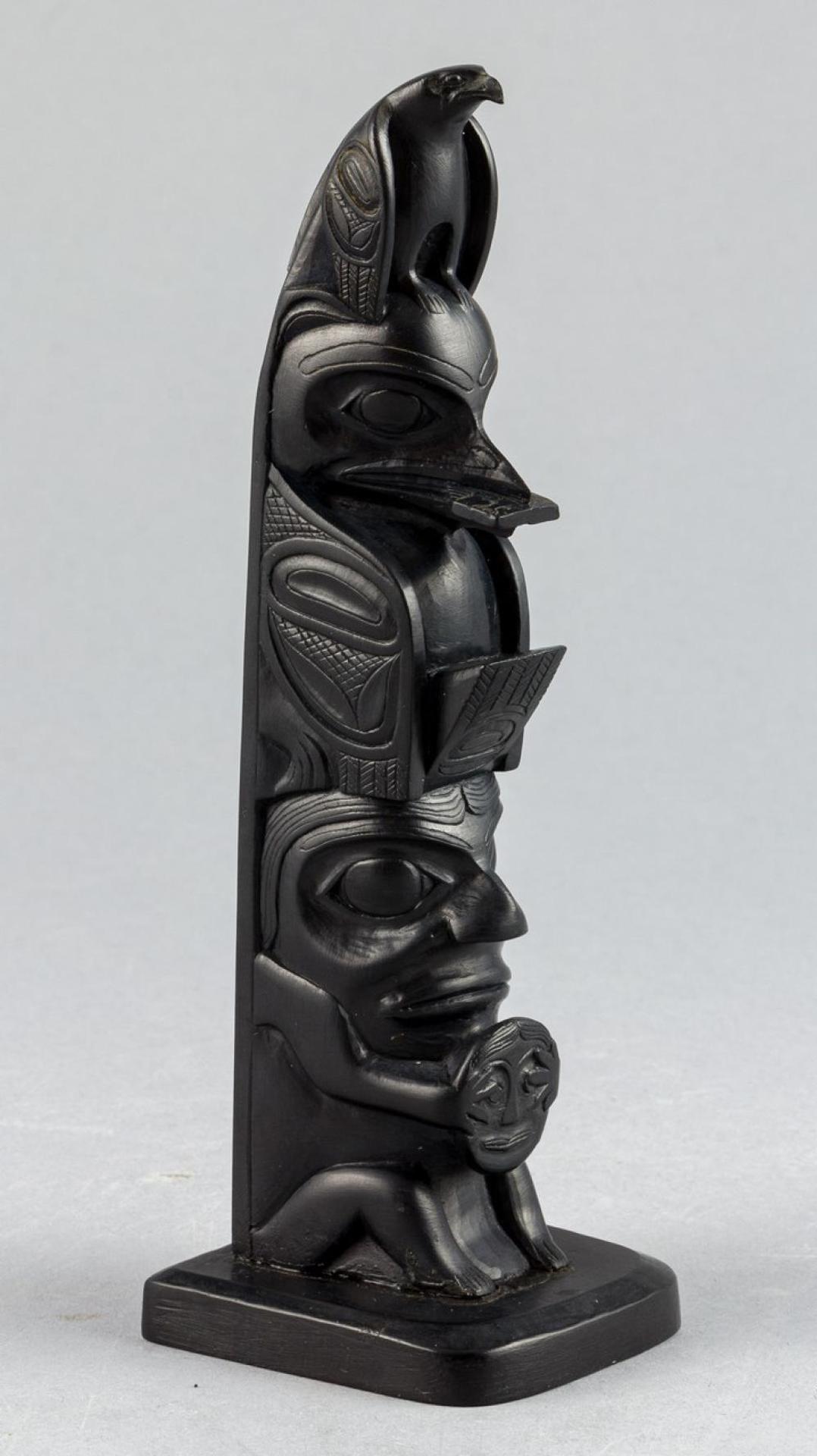 Rufus Moody (1923-1998) - a carved argillite pole depicting Eagle atop Raven and Human figure