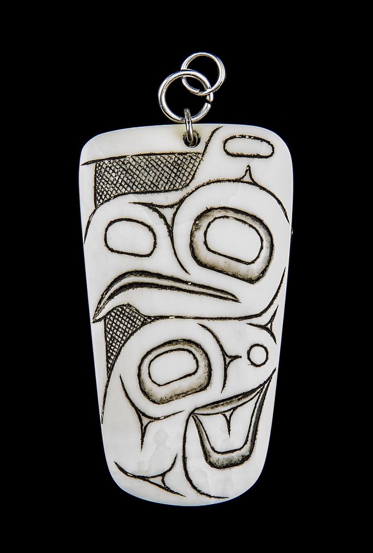 Pat Dixon (1938-2015) - a carved bone pendant decorated with an image of a Raven