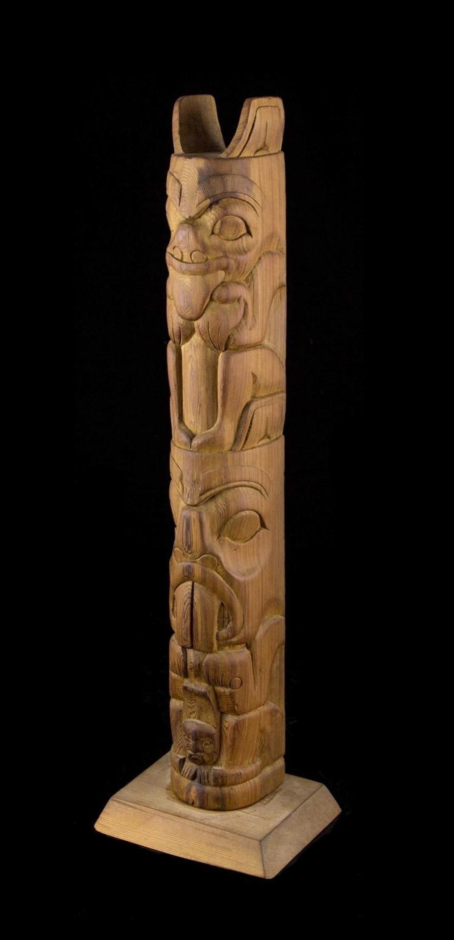 Ben Houstie (1960) - a carved red cedar totem pole depicting Bear on Beaver with Slave Child