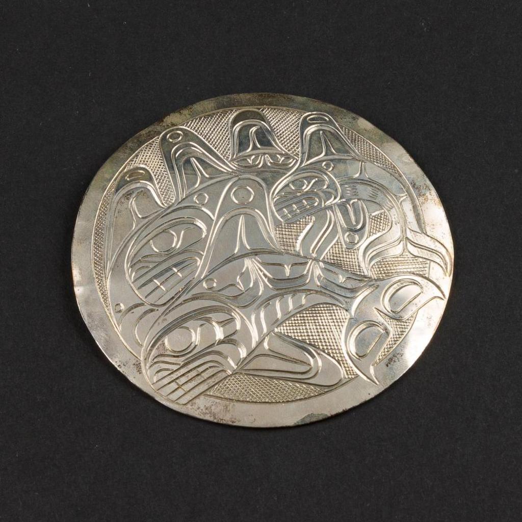 Patrick Seaweed - a large round silver pendant/brooch depicting a pod of killer whales.