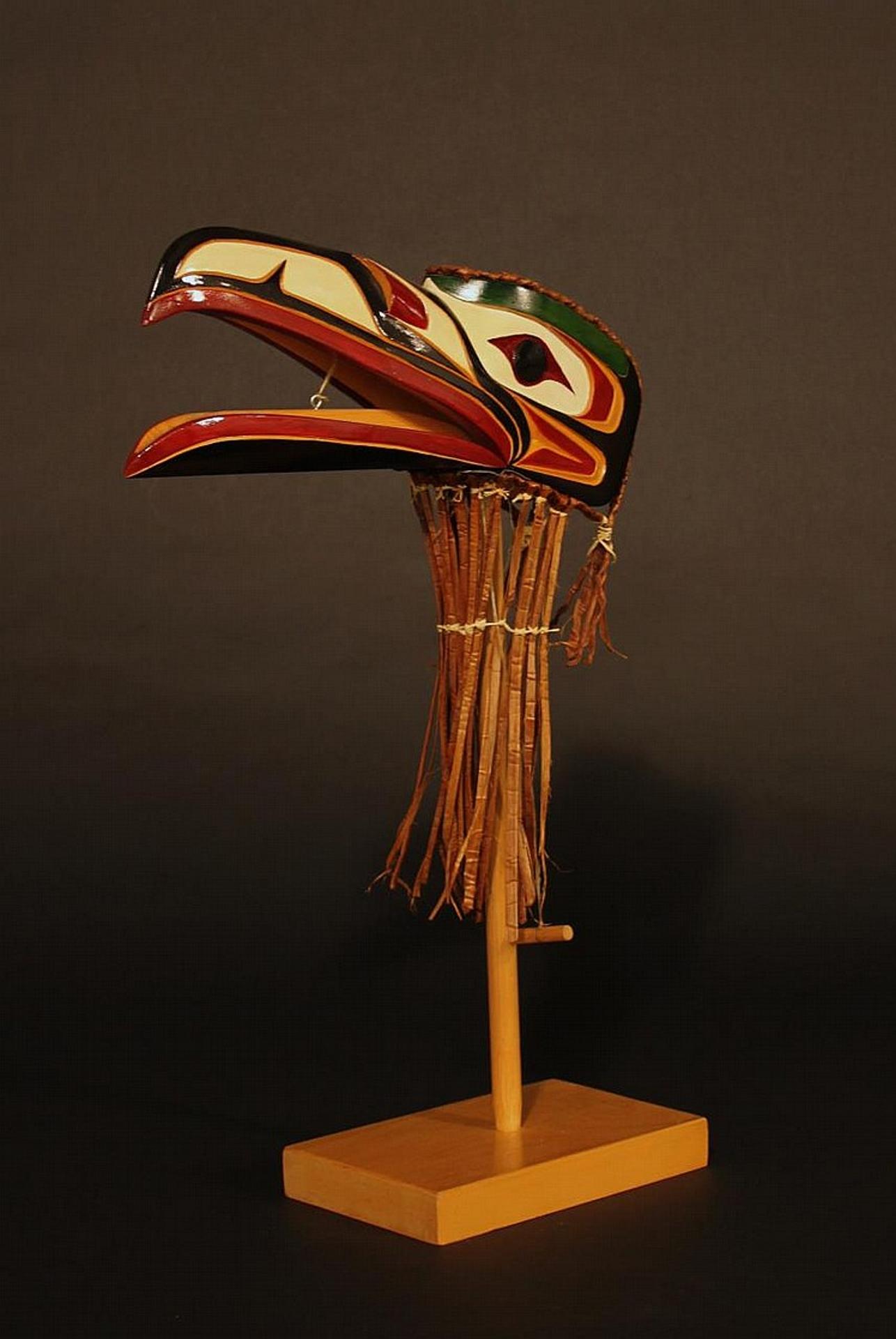 Tommy Paul - a carved and polychromed Raven mask on stand
